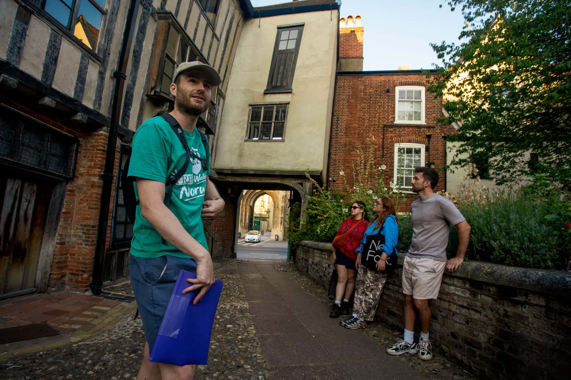 Guide telling a story in Tombland beside the timber-framed Augustine Steward House