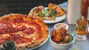 A wood-fired pizza with a side of meatballs at Donnelli's.