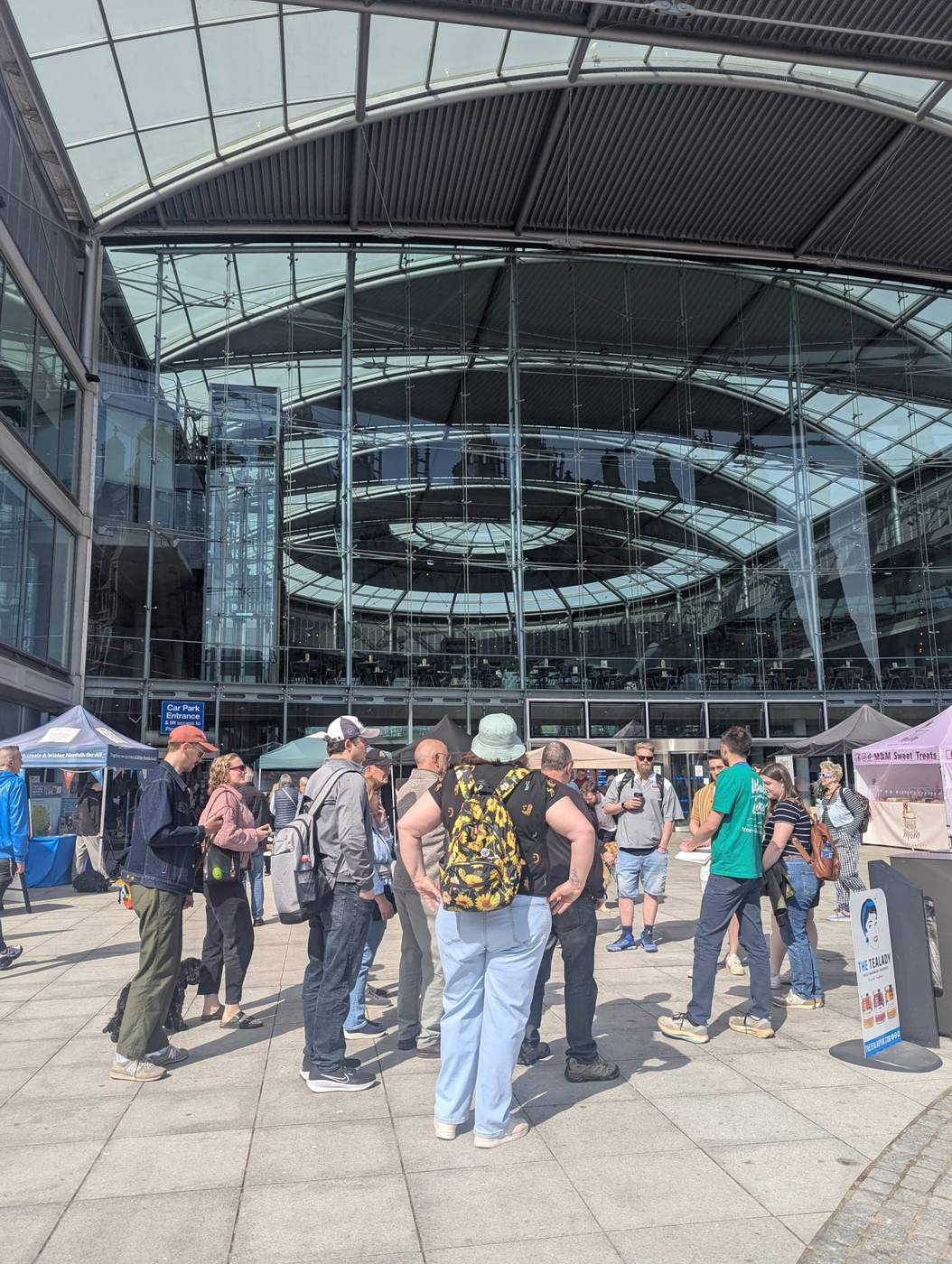 Walking tour group meeting at The Forum, Norwich's modern glass meeting hub on Millennium Plain.