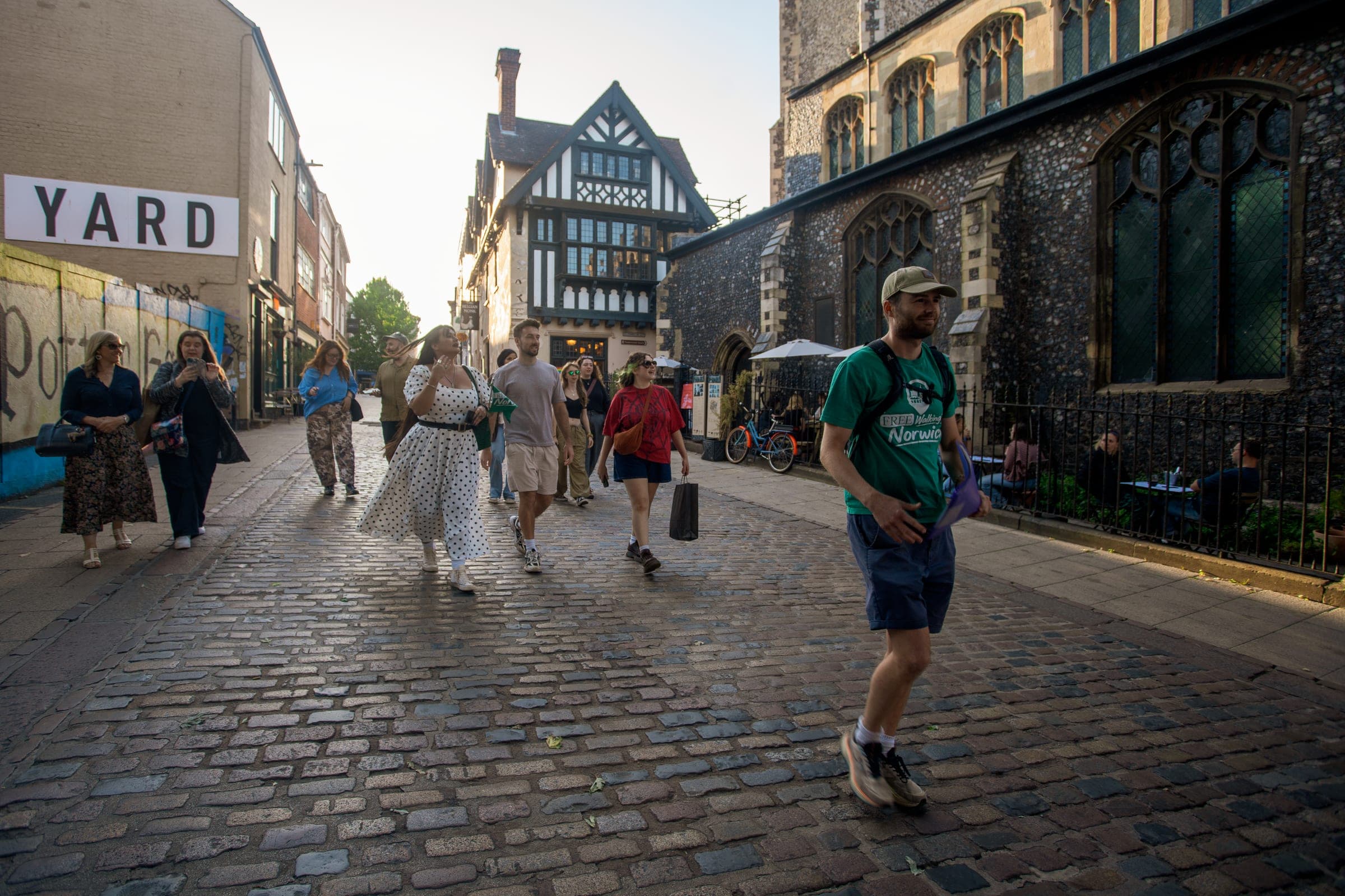 Tour group walking down Pottergate in the Norwich Lanes with their guide on the Norwich Free Walking Tour